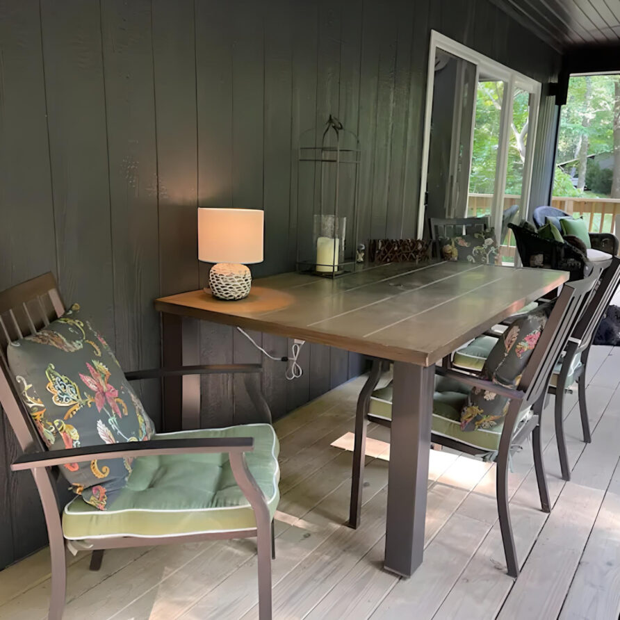 Porch dining area at Moss Creek cabin rental in Southern Illinois, perfect for a luxurious and peaceful nature getaway for families.