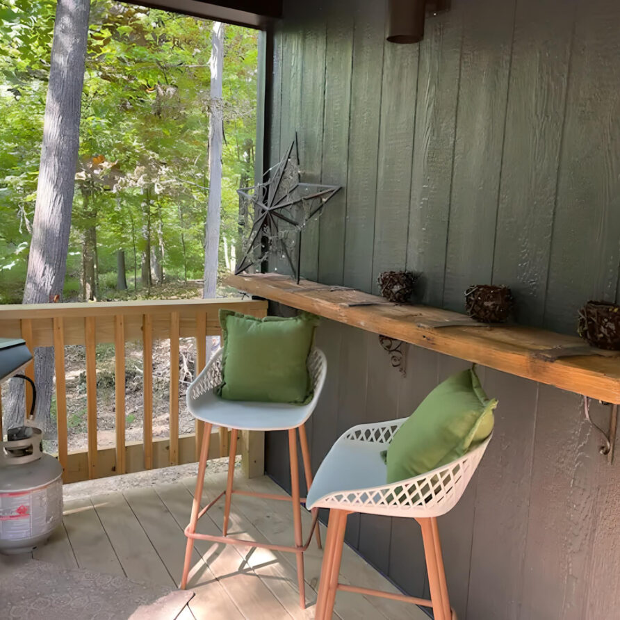 Porch dining area with grill at Moss Creek cabin rental in Southern Illinois, perfect for a luxurious and peaceful nature getaway for families.